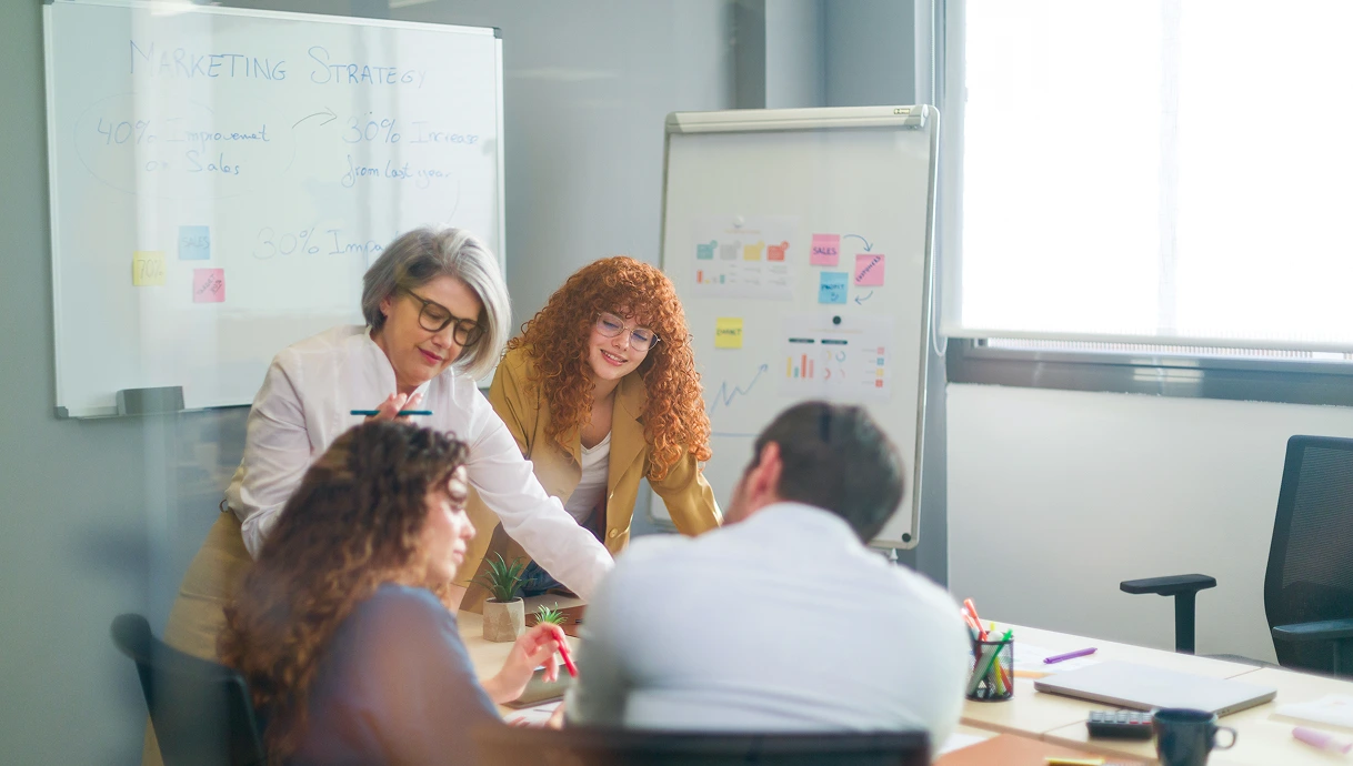 Equipo desarrollando una estrategia de marketing en una sala de reuniones de THE LED coworking, con pizarras llenas de ideas y un ambiente colaborativo y profesional.