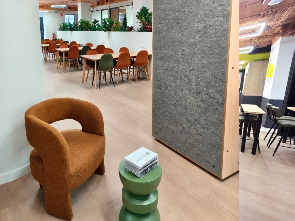 Butaca naranja junto a un panel de fieltro
